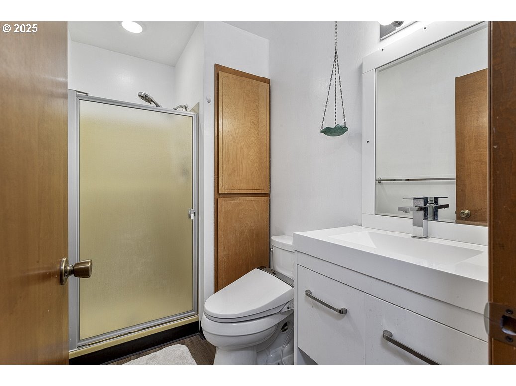14850 Northeast Rose Parkway, Unit 67A Portland, OR 97230 - Photo 20 of 33 a bathroom with a sink a toilet a mirror and shower
