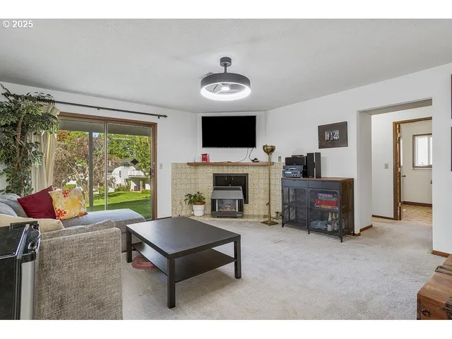 a living room with furniture a flat screen tv and a fireplace