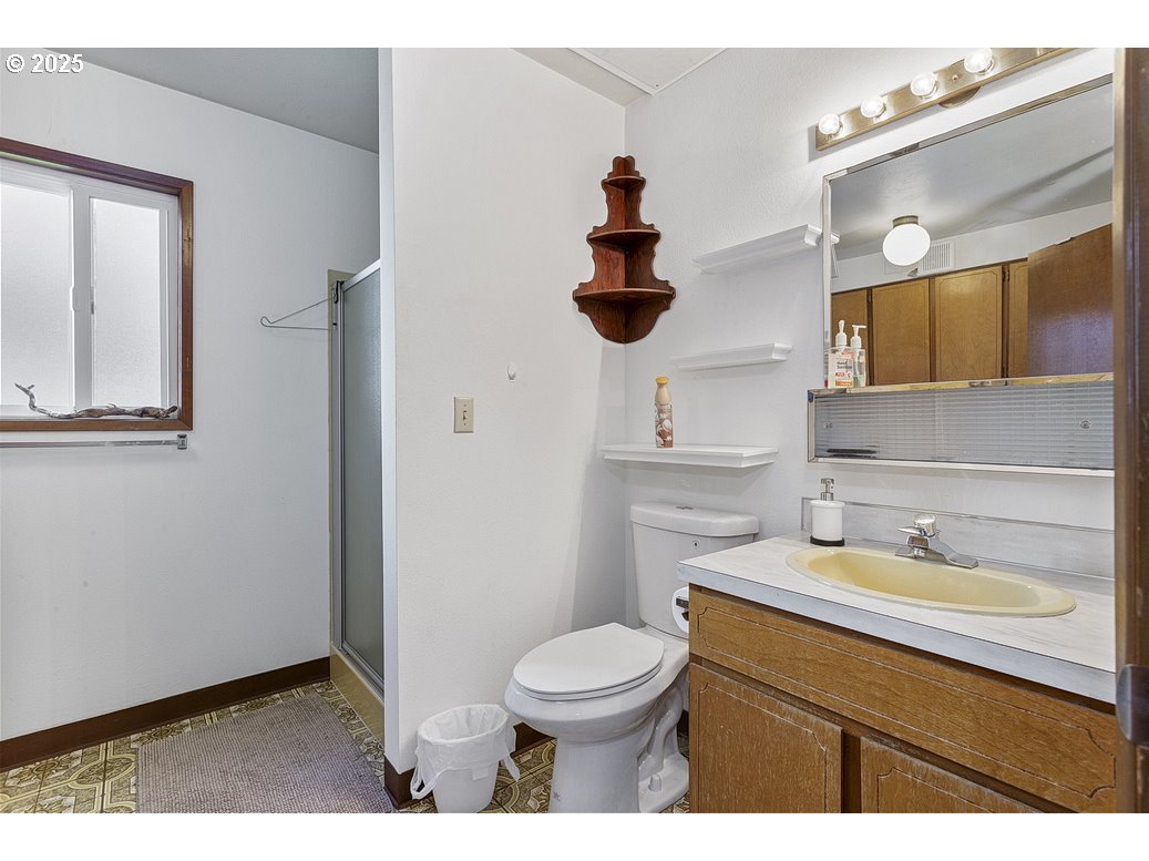 14850 Northeast Rose Parkway, Unit 67A Portland, OR 97230 - Photo 24 of 33 a bathroom with a sink a toilet and mirror
