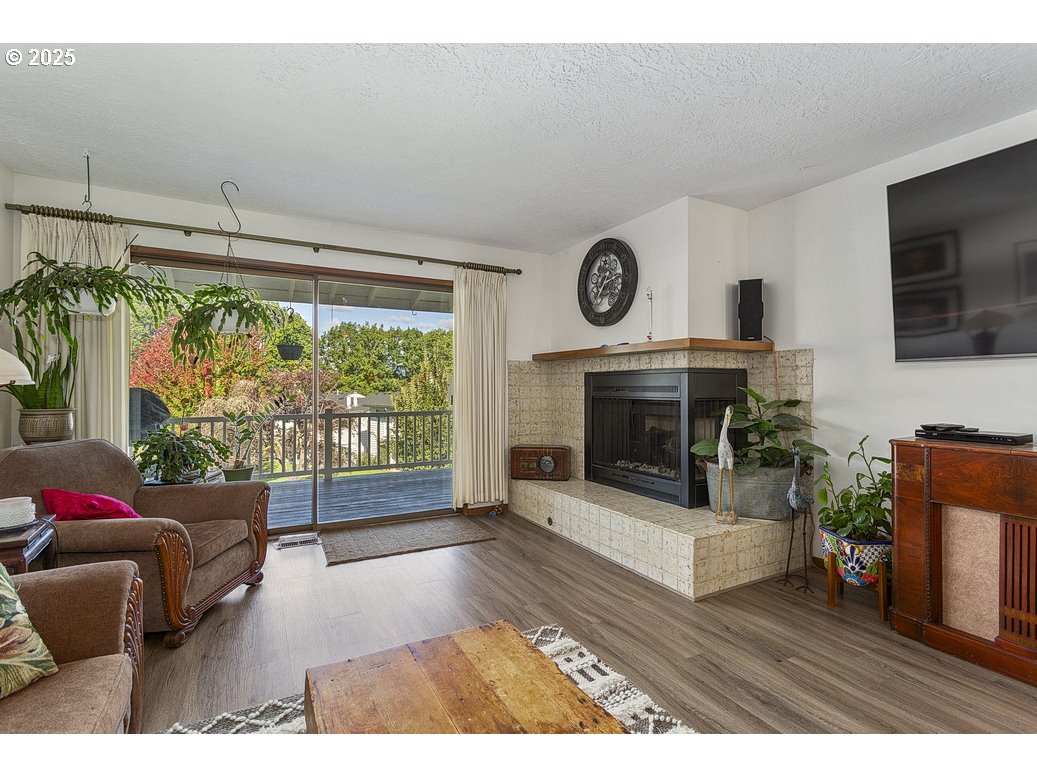 14850 Northeast Rose Parkway, Unit 67A Portland, OR 97230 - Photo 5 of 33 a living room with furniture a flat screen tv and a fireplace