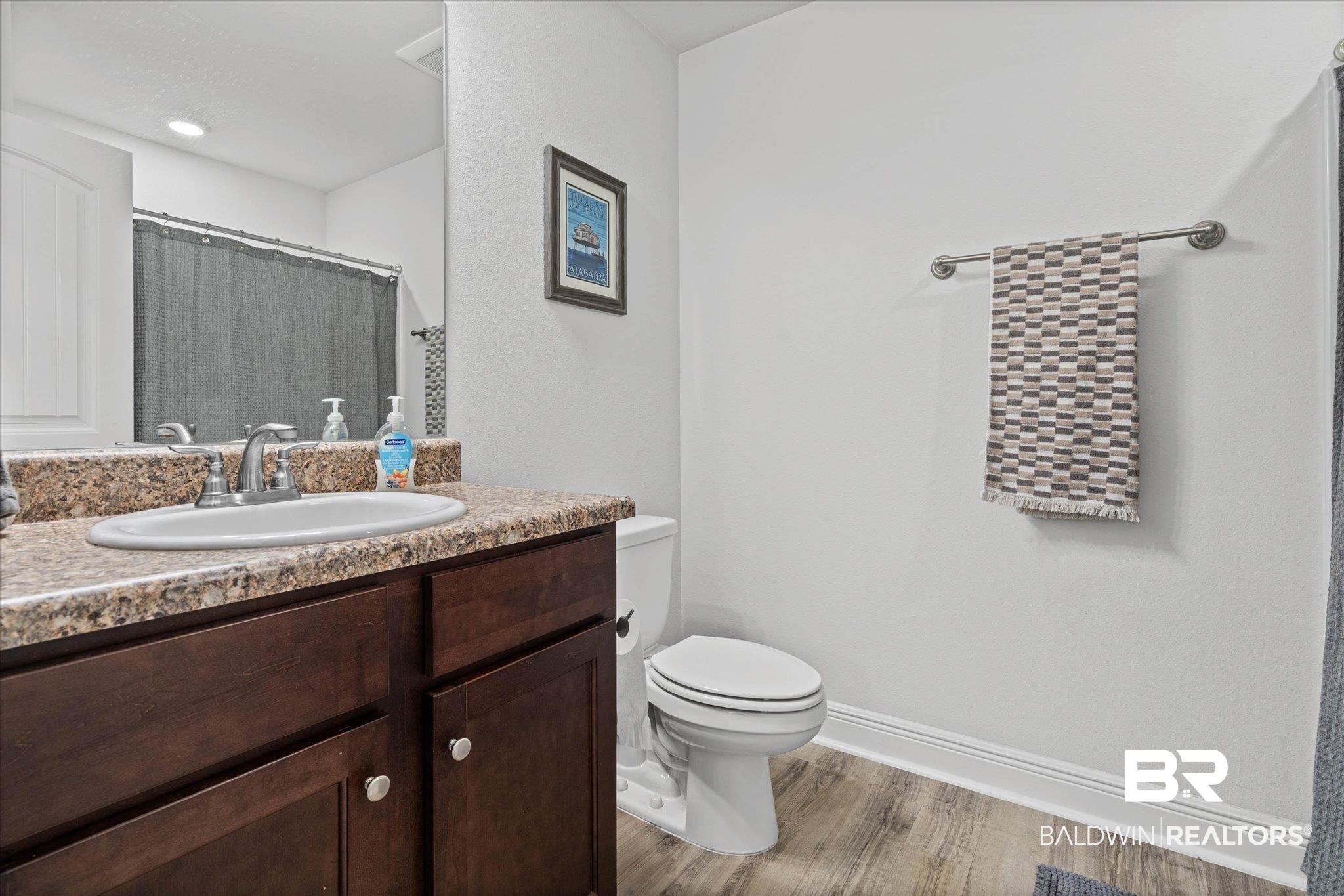 22420 Respite Lane Foley, AL 36535 - Photo 16 of 35 Bathroom featuring a wood-finish vanity with an integrated sink and a speckled countertop