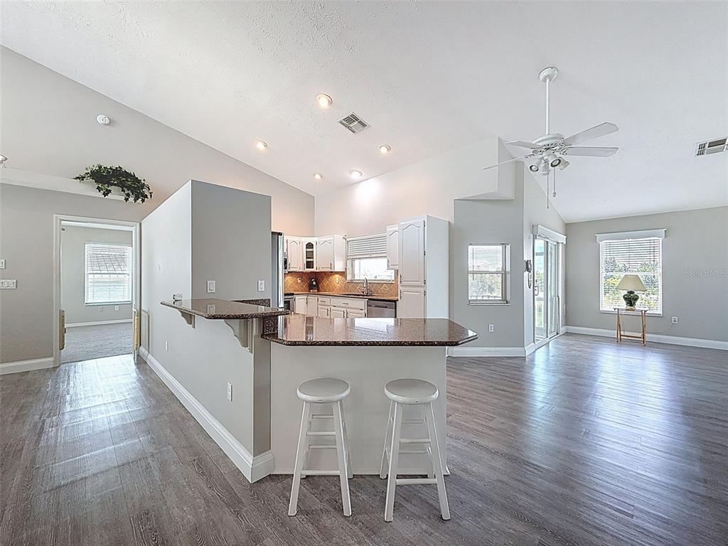 3342 Turks Cap Drive Hernando Beach, FL 34607 - Photo 18 of 94 a kitchen with stainless steel appliances kitchen island granite countertop a table chairs refrigerator and microwave