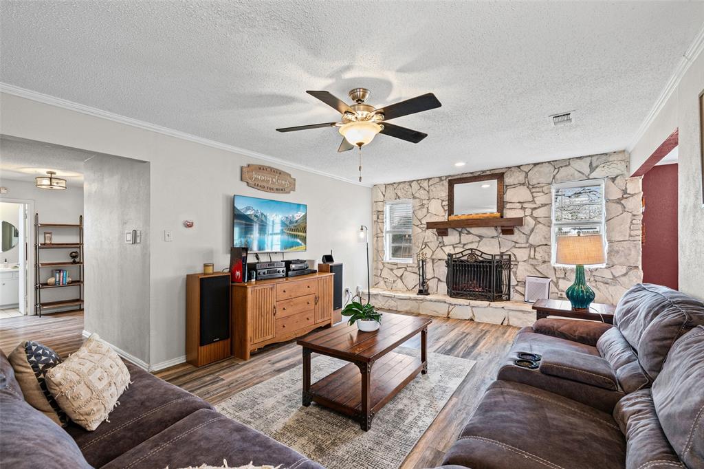 3900 Cresthill Road Benbrook, TX 76116 - Photo 6 of 18 a living room with furniture a fireplace and a chandelier