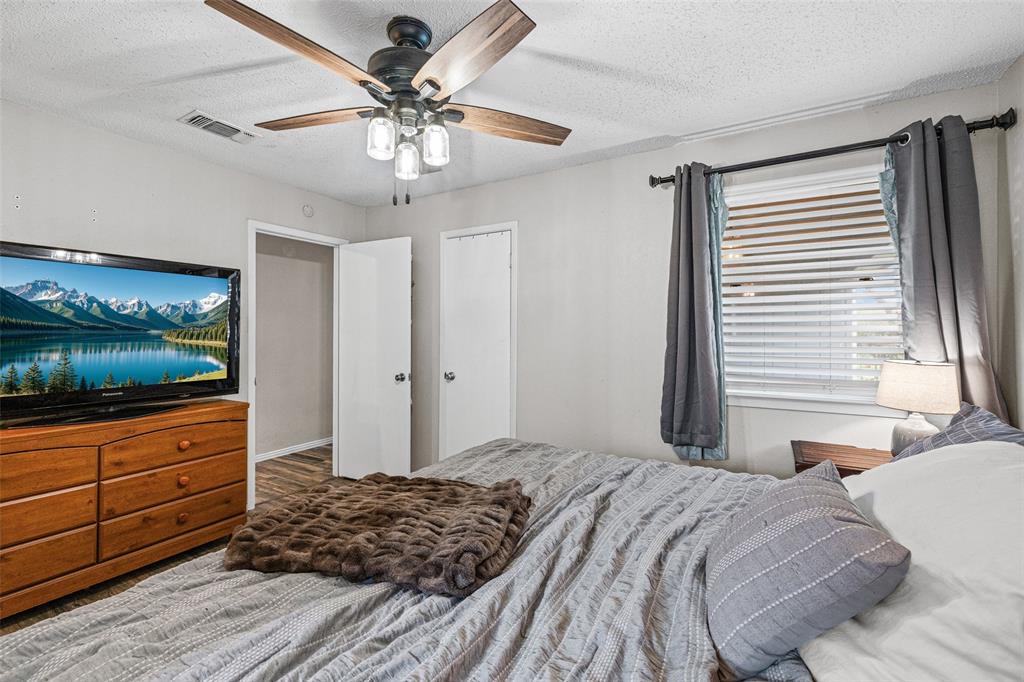 3900 Cresthill Road Benbrook, TX 76116 - Photo 10 of 18 a bedroom with a large bed and a chandelier