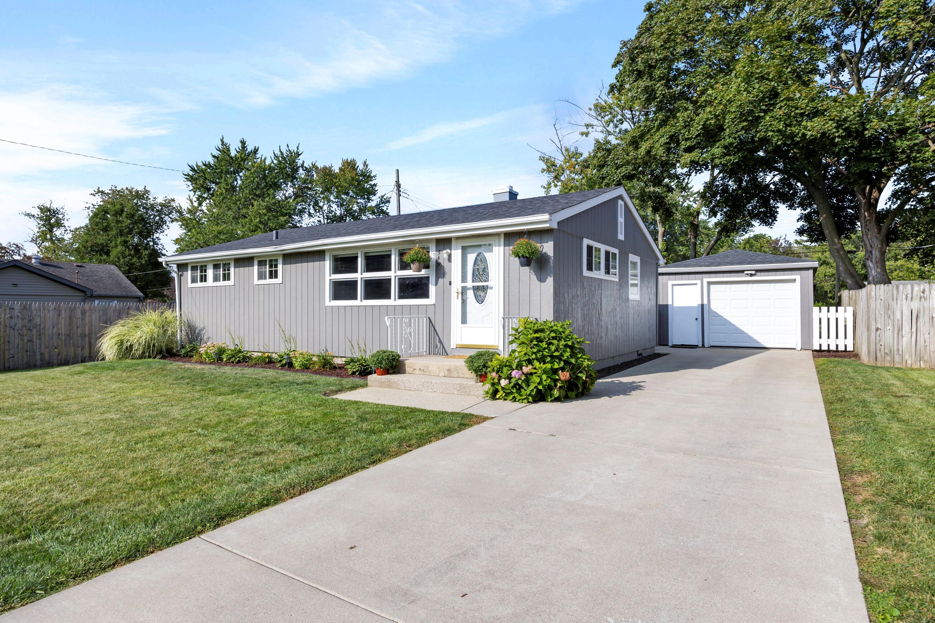 a front view of a house with a yard and potted plants