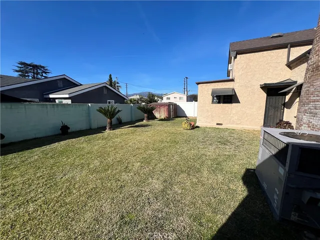 a view of a house with backyard and sitting area