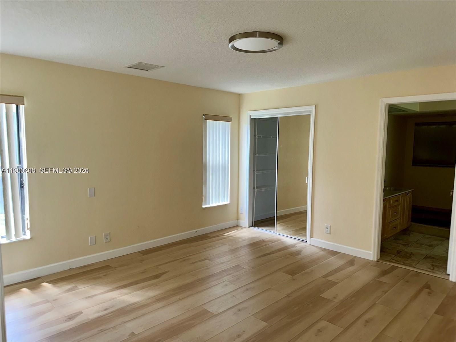 18352 181st Circle South Boca Raton, FL 33498 - Photo 8 of 13 an empty room with wooden floor and windows