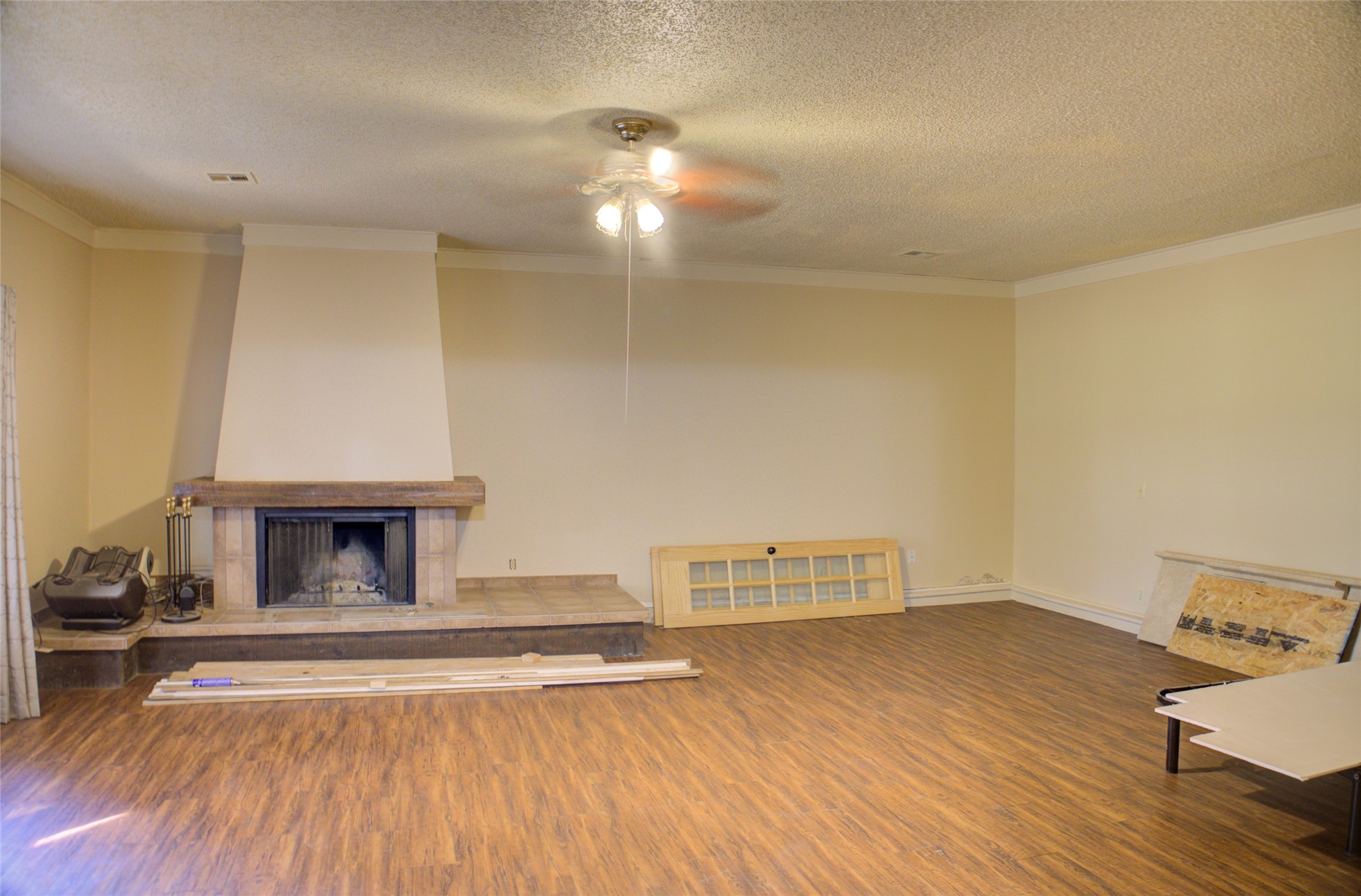 12420 South Garnett Road Broken Arrow, OK 74011 - Photo 23 of 44 Expansive room featuring wood-finish flooring, a ceiling fan, and crown molding