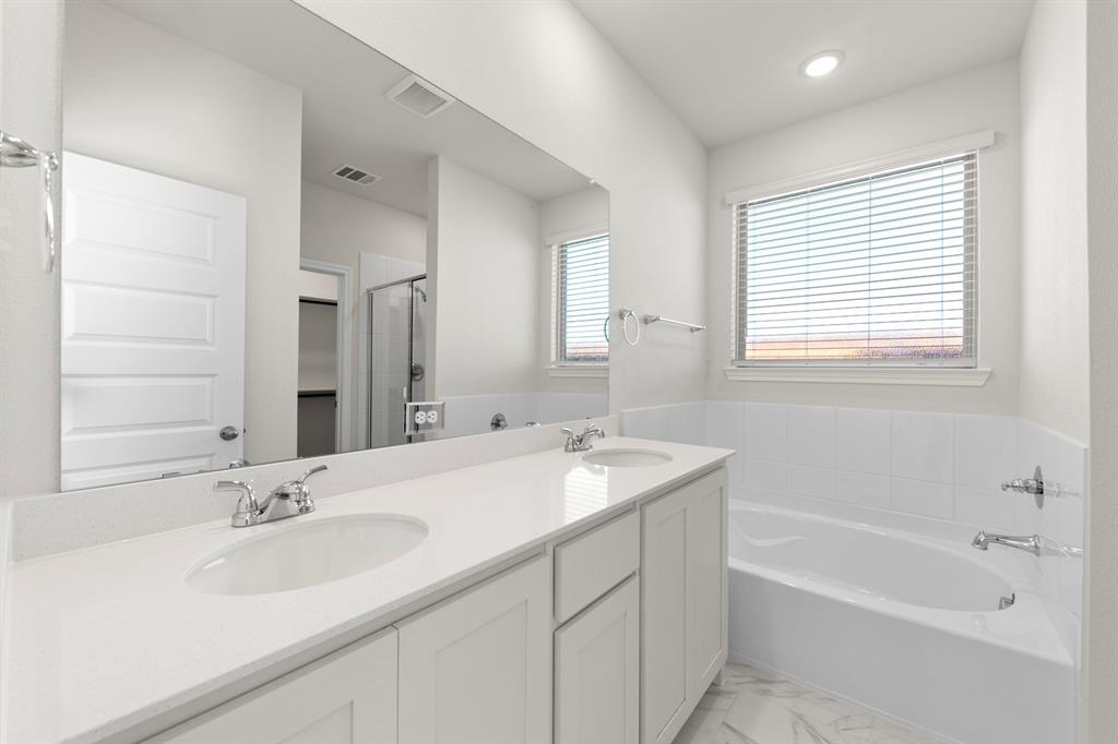 125 Pheasant Run Road Terrell, TX 75160 - Photo 21 of 27 a bathroom with a sink double vanity granite tub shower and a mirror