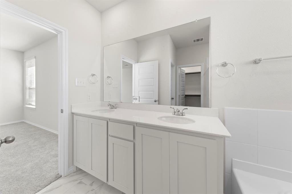 125 Pheasant Run Road Terrell, TX 75160 - Photo 23 of 27 a bathroom with double sink and a mirror