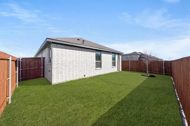 a view of a backyard with potted plants and wooden fence