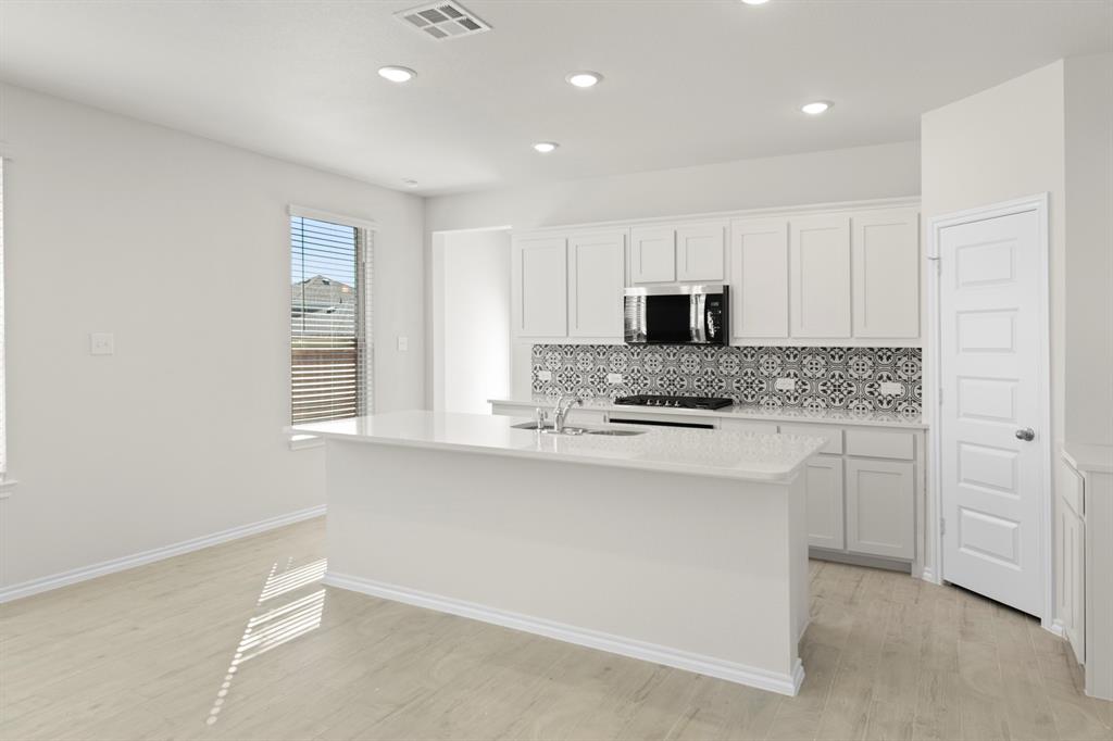 125 Pheasant Run Road Terrell, TX 75160 - Photo 7 of 27 a kitchen with white cabinets and stainless steel appliances