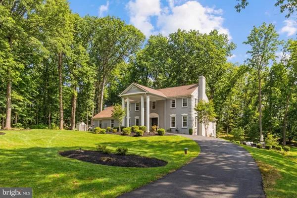 a view of a house with a big yard and large trees