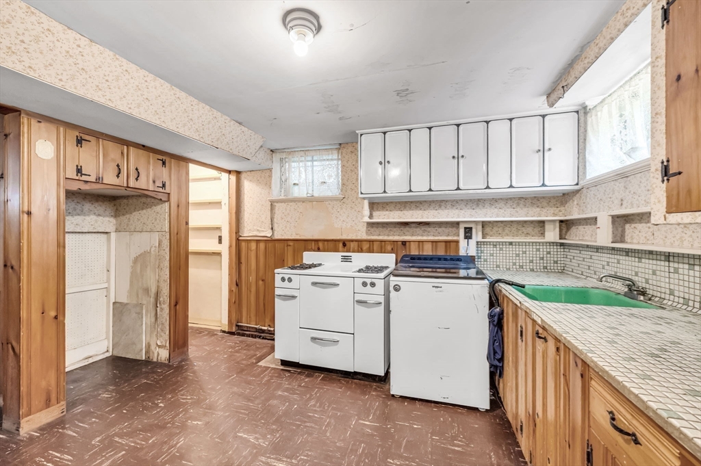 55 Pasadena Street Springfield, MA 01108 - Photo 27 of 33 a kitchen with a stove top oven sink and cabinets