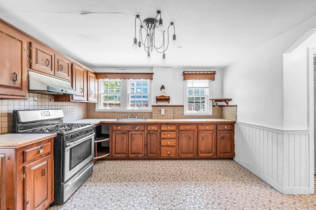 55 Pasadena Street Springfield, MA 01108 - Photo 3 of 33 a kitchen with stainless steel appliances granite countertop a stove a sink and a microwave