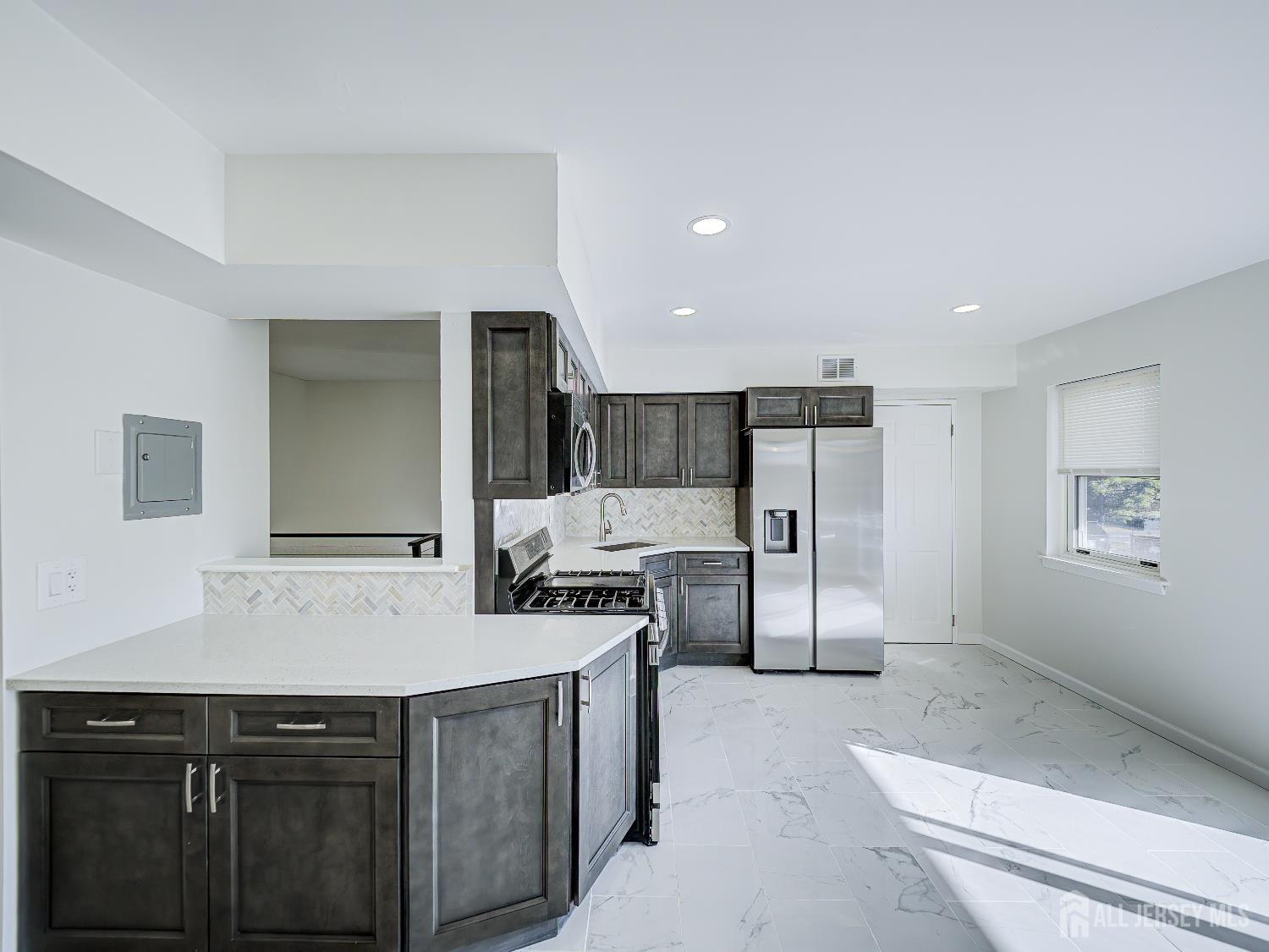 18 Judson Street, Unit 22B Edison, NJ 08837 - Photo 15 of 34 a kitchen with stainless steel appliances kitchen island granite countertop a refrigerator and a stove top oven