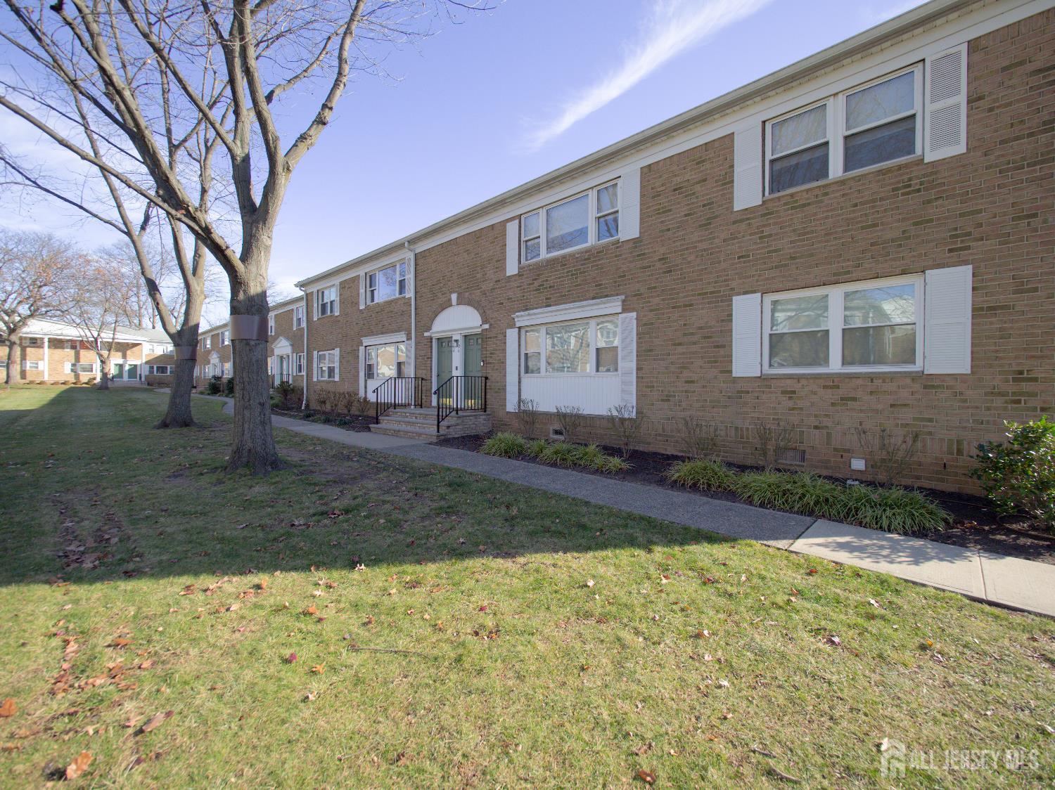 18 Judson Street, Unit 22B Edison, NJ 08837 - Photo 23 of 34 a view of a yard in front of a brick house with large windows