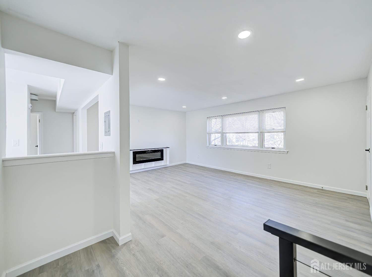 18 Judson Street, Unit 22B Edison, NJ 08837 - Photo 8 of 34 an empty room with wooden floor and windows