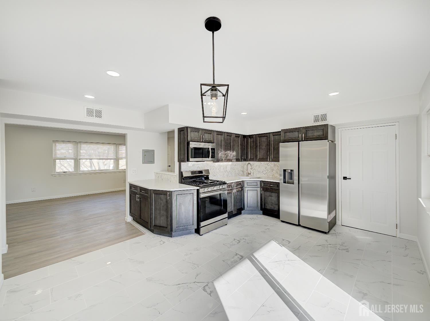 18 Judson Street, Unit 22B Edison, NJ 08837 - Photo 10 of 34 a kitchen with stainless steel appliances a refrigerator a sink dishwasher a oven with a dining table and chairs
