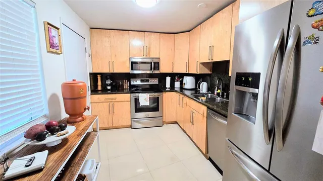 a kitchen with stainless steel appliances a refrigerator sink and stove