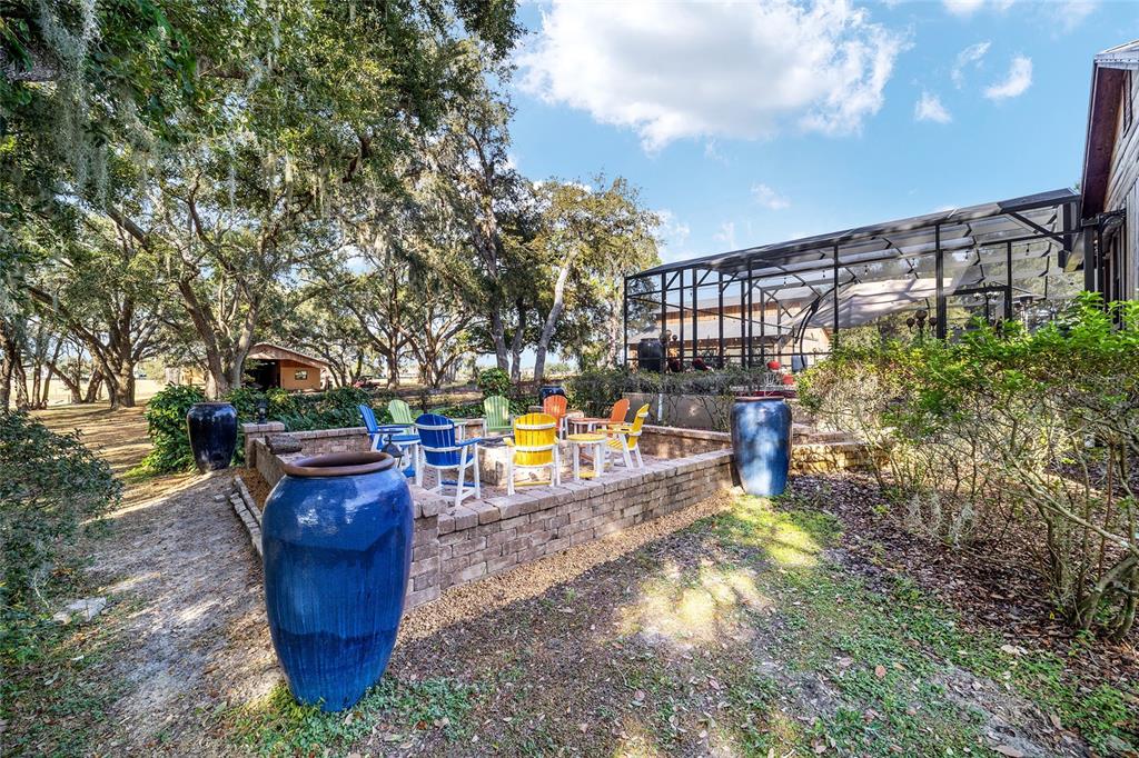 36203 Micro Racetrack Road Fruitland Park, FL 34731 - Photo 31 of 72 a view of a swimming pool with a patio and fire pit