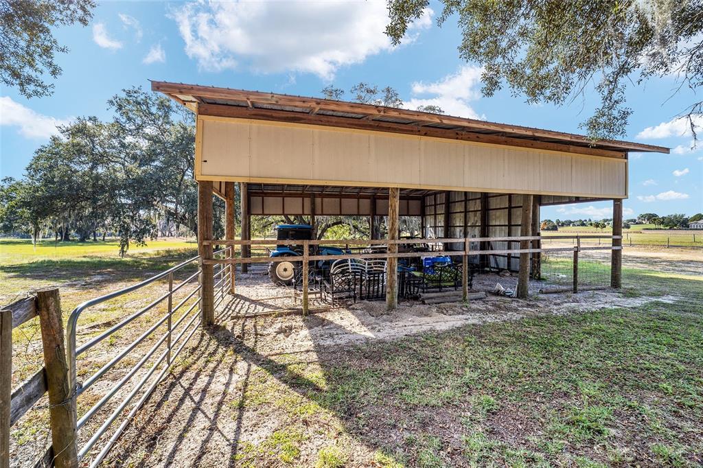 36203 Micro Racetrack Road Fruitland Park, FL 34731 - Photo 45 of 72 a view of a patio with dining table and chairs with wooden floor
