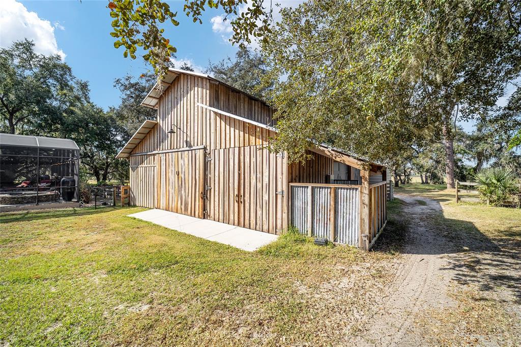 36203 Micro Racetrack Road Fruitland Park, FL 34731 - Photo 53 of 72 a backyard of a house with wooden fence and large trees