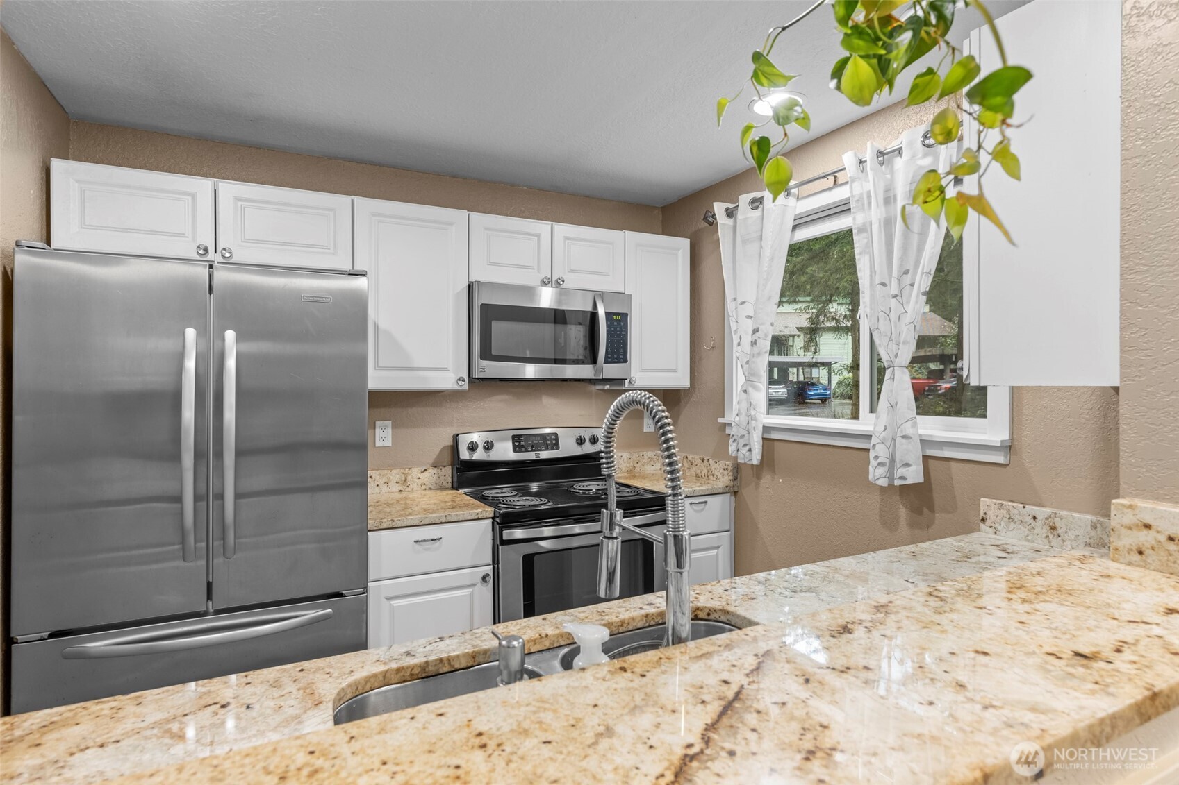 157 South 330th Street, Unit A Federal Way, WA 98003 - Photo 3 of 21 a kitchen with stainless steel appliances granite countertop a refrigerator a stove a sink dishwasher a dining table and chairs with wooden floor