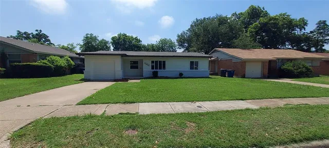 a view of a house with a big yard and potted plants