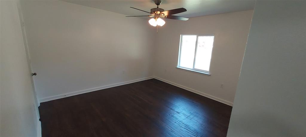 12202 Bellafonte Drive Dallas, TX 75243 - Photo 11 of 14 an empty room with wooden floor closet fan and windows