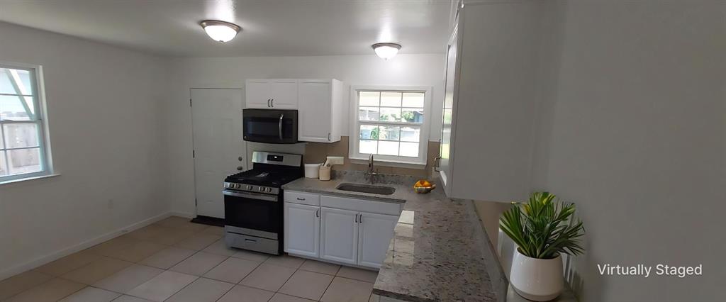 12202 Bellafonte Drive Dallas, TX 75243 - Photo 4 of 14 a kitchen with a sink and a stove top oven