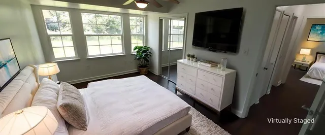 a bedroom with a bed and a flat tv screen on dresser