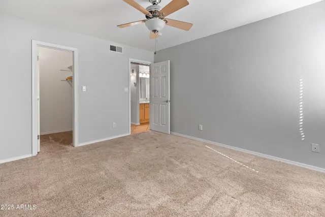an empty room with a window and a fan