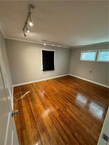 a view of empty room with wooden floor