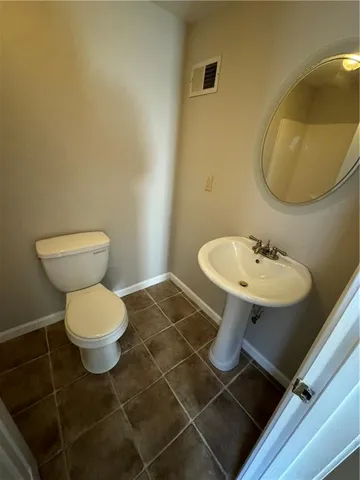 a bathroom with a sink toilet and a mirror