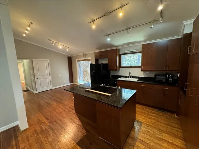 a kitchen with kitchen island granite countertop a sink stove and refrigerator