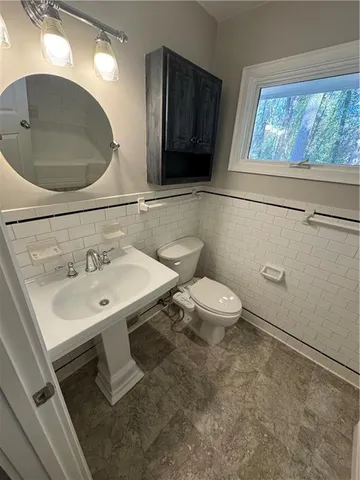 a bathroom with a toilet sink and mirror