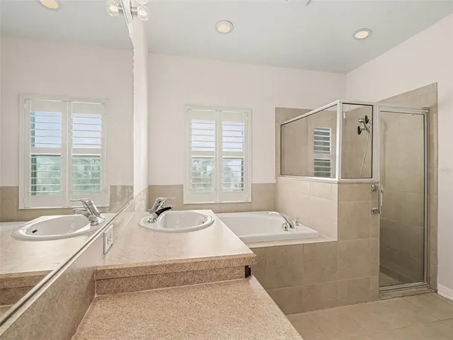 a bathroom with a granite countertop tub sink and mirror