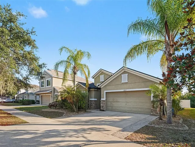 a view of a house with a yard and palm trees