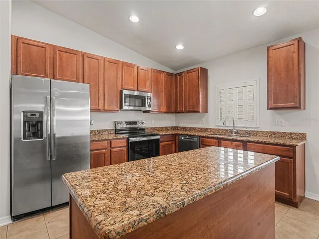 a kitchen with stainless steel appliances granite countertop a refrigerator sink and microwave