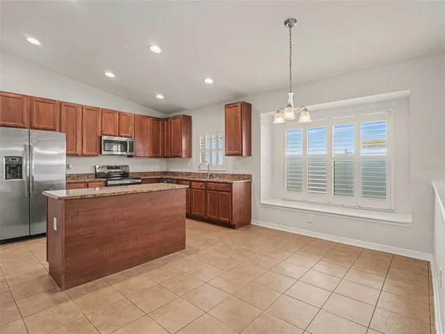 a kitchen with stainless steel appliances granite countertop a stove a sink a refrigerator and a microwave