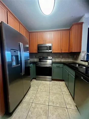 a kitchen with granite countertop a stove top oven and cabinets