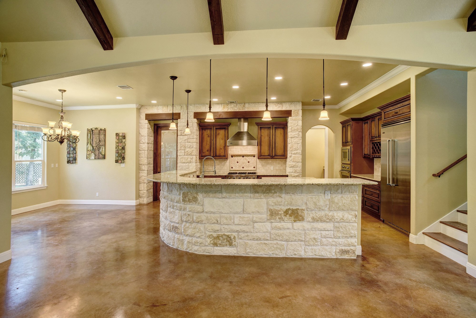 115 Pine Point Cove Elgin, TX 78621 - Photo 8 of 39 Exposed wood beams and a stone-clad kitchen island anchor this inviting open-concept living space.