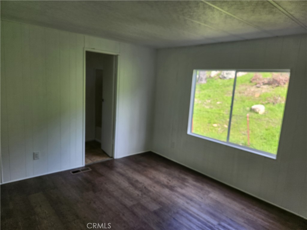 356 Chinese Wall Road Oroville, CA 95966 - Photo 14 of 30 an empty room with wooden floor and windows
