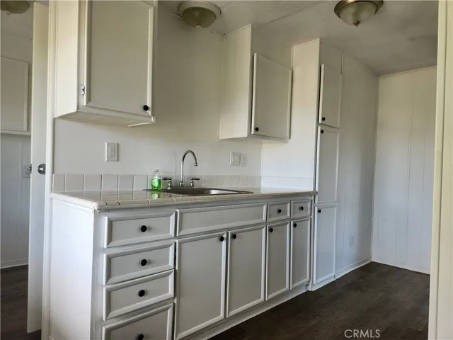 a kitchen with granite countertop white cabinets and sink