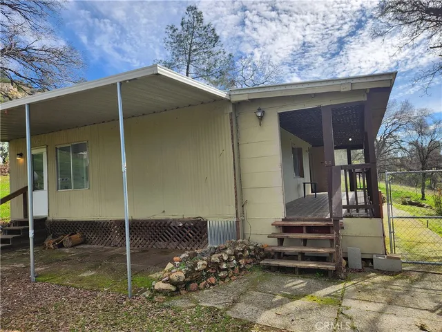 a backyard of a house with barbeque oven table and chairs