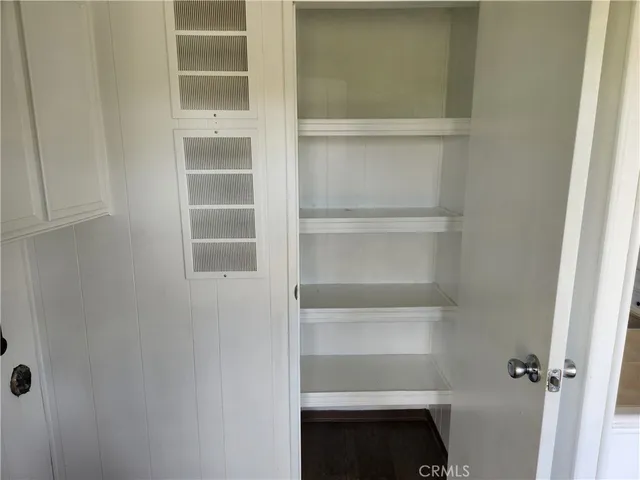 a view of walk in closet with empty racks