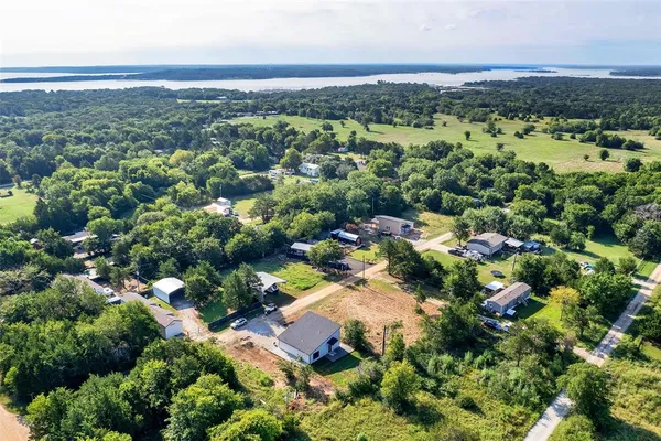 an aerial view of residential houses with outdoor space and trees