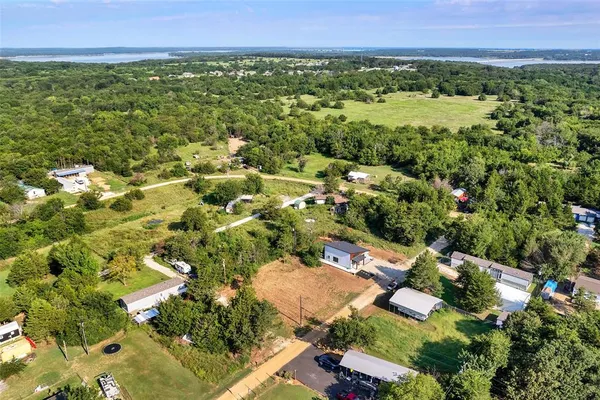 an aerial view of residential houses with outdoor space and trees