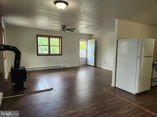 a view of a livingroom with wooden floor and a ceiling fan